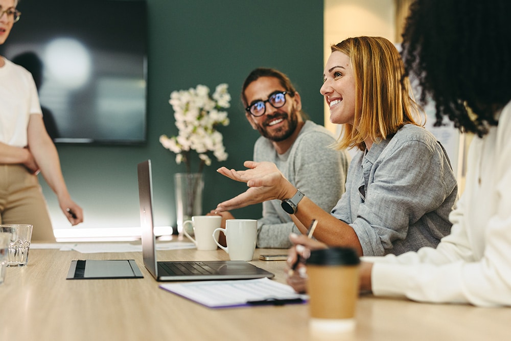 Team of employees working collaboratively together around a table